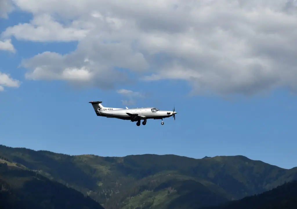 Vue d'un jet privé - Pilatus PC12 - en vol au dessus des montagnes.